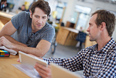 Buy stock photo Shot of business colleagues discussing matters with the help of wireless technology in their office