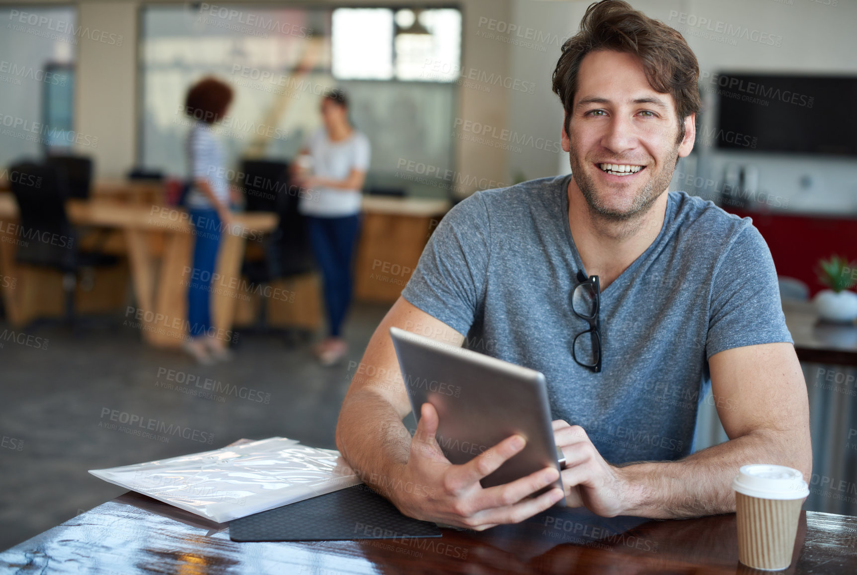 Buy stock photo Portrait of a young man using a digital tablet in an office