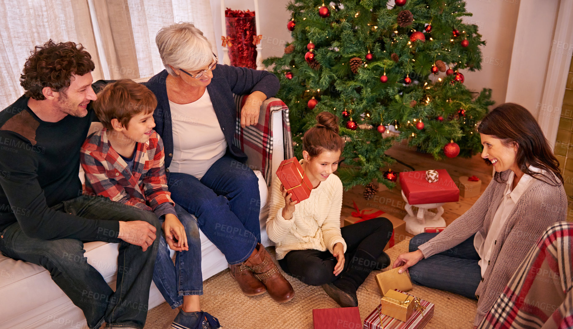 Buy stock photo Christmas, family and open present in lounge, happy and smile together for festive season. Xmas, grandma and parents with children, gifts and happiness for celebration, joy and holiday in living room