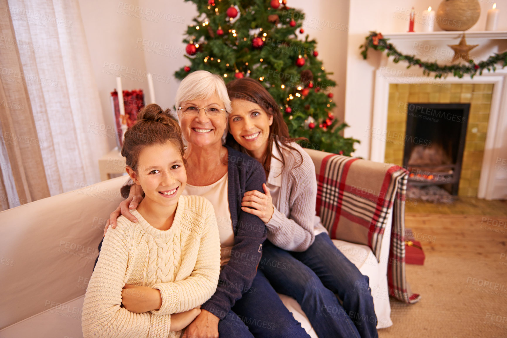 Buy stock photo Grandmother, mother and girl on sofa at Christmas enjoying holiday, vacation and festival celebration. Family, love and and portrait of mom bonding with grandma and child with Christmas tree in home