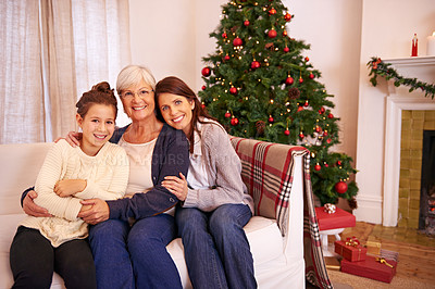 Buy stock photo Christmas, portrait and family on sofa by mother, girl and grandma in celebration of bonding tradition in their home. Happy family, generations and women embrace in living room for festive vacation 