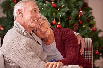 Buy stock photo Christmas, love and senior couple hug on sofa in home, affection and bonding. Romance, xmas holiday and happy elderly, retired woman and man embrace on couch enjoying quality time together in house