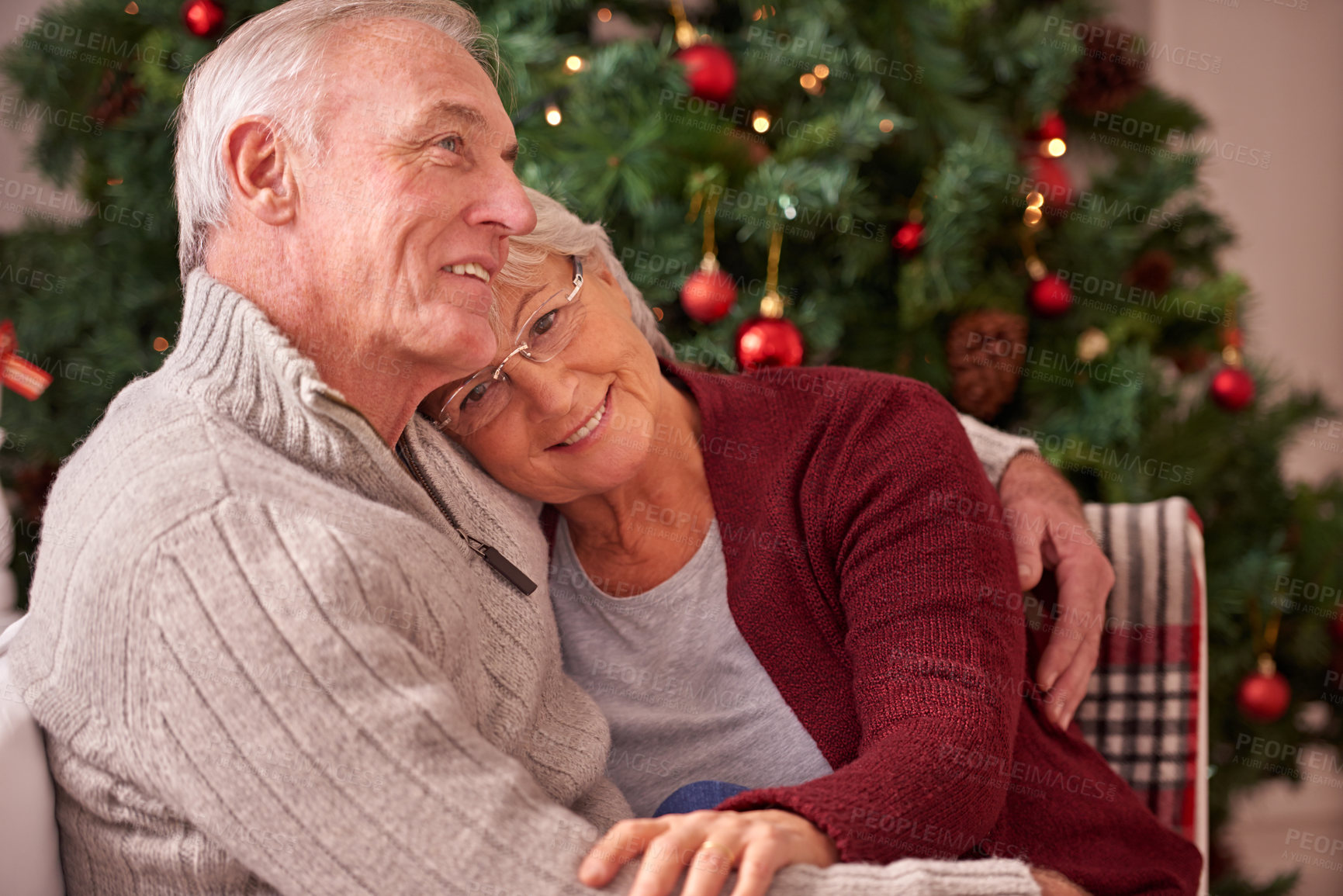 Buy stock photo Christmas, love and senior couple hug on sofa in home, affection and bonding. Romance, xmas holiday and happy elderly, retired woman and man embrace on couch enjoying quality time together in house