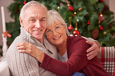 Buy stock photo Christmas, love and portrait of a senior couple hugging, bonding and relaxing on a sofa together. Happy, smile and elderly man and woman in retirement celebrating xmas at a festive party at home.