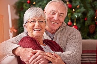 Buy stock photo Senior couple, Christmas and love for holiday celebration with a hug, smile and happiness together on a living room sofa. Portrait of a old man and woman partner celebrate a happy marriage in festive