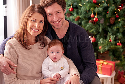 Buy stock photo Family, christmas portrait and relax on sofa with baby to celebrate festive holiday together. Smile, happy quality time and celebration for love, care and support on xmas with christmas tree at home