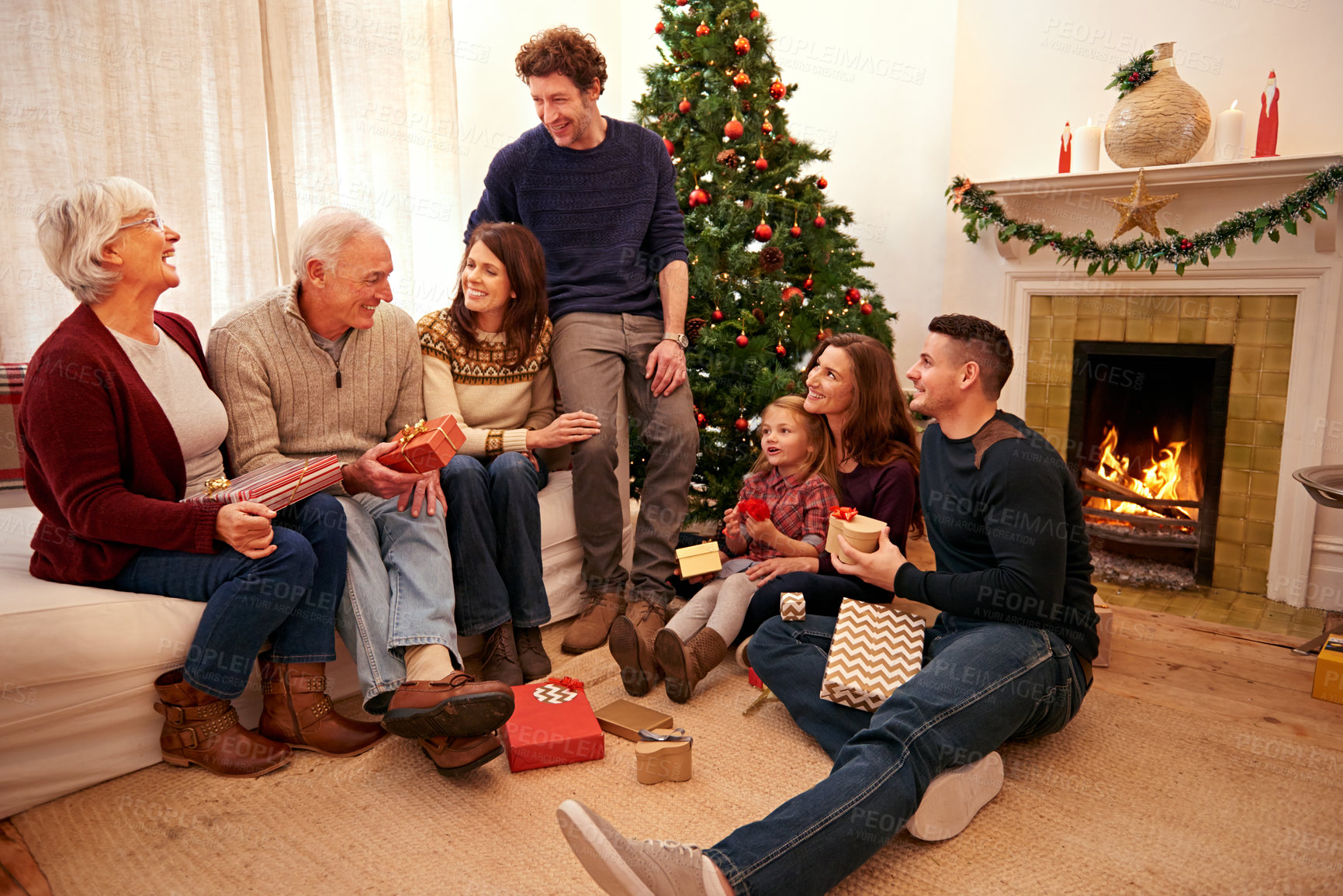 Buy stock photo Family, Christmas and giving gift and holiday celebration, generations with tradition and together in living room. Happy family, celebrate festive season at home and Christmas tree and decoration.
