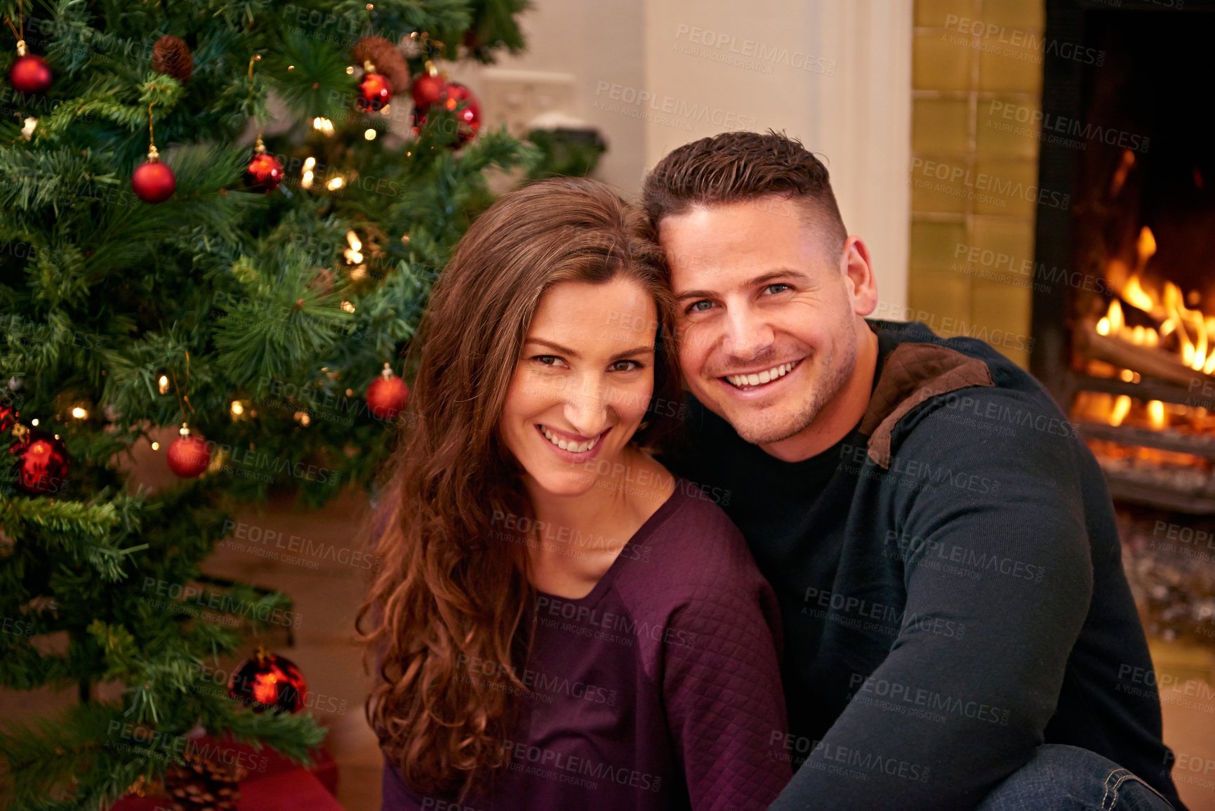 Buy stock photo Couple, christmas and portrait together in home with smile, happiness and bonding with christmas tree. Man, woman and happy by fireplace for celebration, party and holiday spirit on living room floor