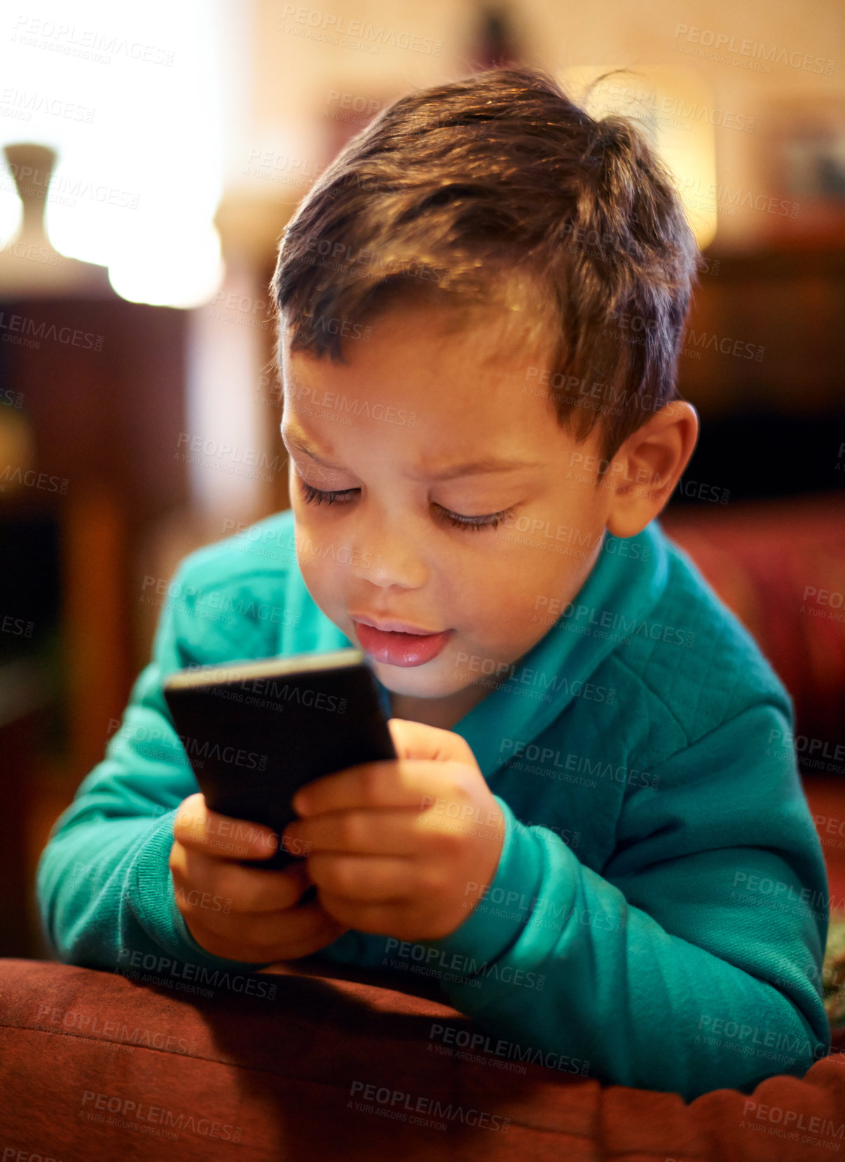 Buy stock photo young boy, watch and play smartphone games in house for school vacation or weekend away. Little boy, cellphone and watching video for education, in living room for distance learning or fun. 