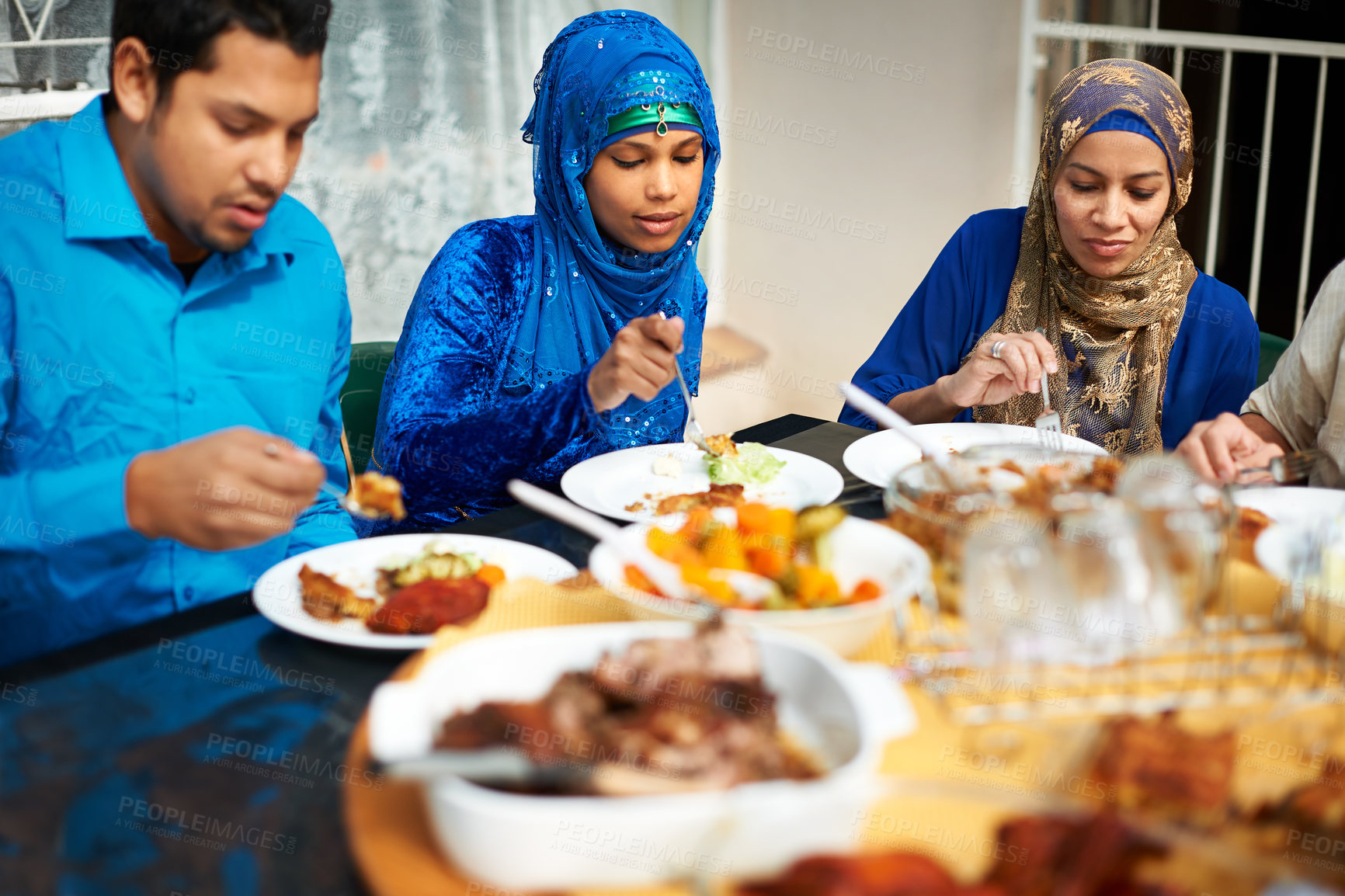 Buy stock photo Family, eating and home with food for eid, islam and celebration around table and happy with cooking. Islamic people, man and women and together for ramadan in house for conversation and lunch   