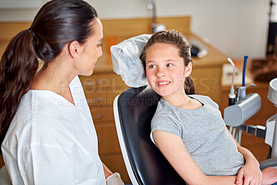 Buy stock photo Dentist, child and oral hygiene consultation with conversation and talk for dental care. Clinic, smile and young girl with healthcare and wellness advice for mouth and teeth health at appointment