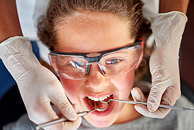 Buy stock photo High angle shot of a young girl having her teeth examined by a dentist