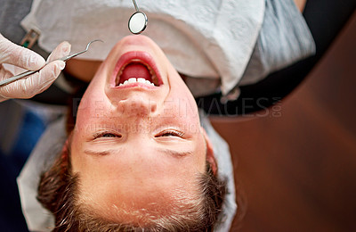 Buy stock photo High angle shot of a young girl having her teeth examined by a dentist