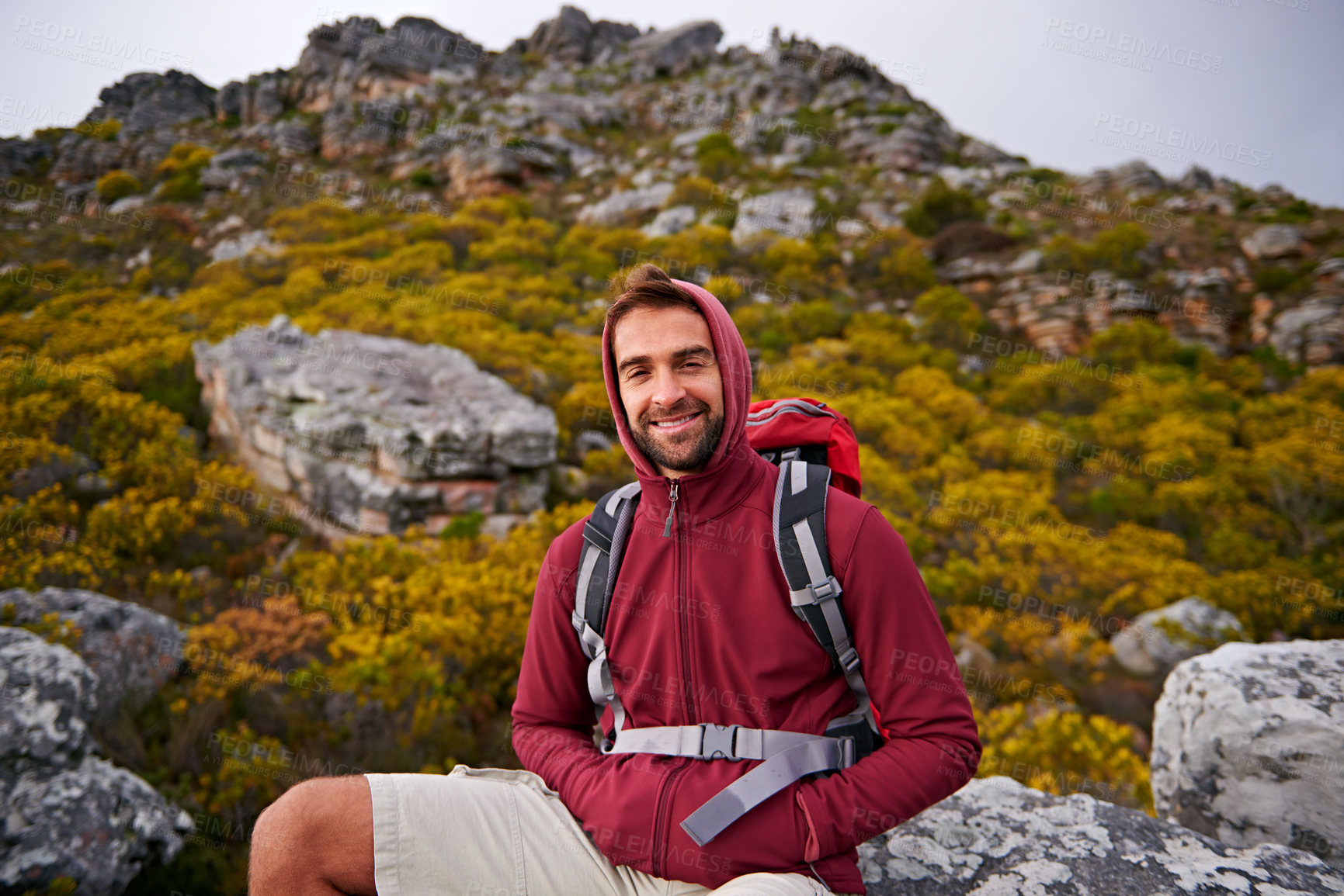 Buy stock photo Hiking, portrait and man on mountain, nature and rock for outdoor adventure with happiness. Male person, athlete and sport in environment for exercise, fitness and health with backpack by landscape