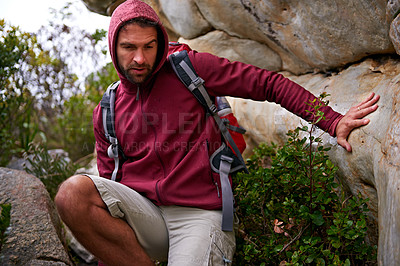 Buy stock photo Cave, rock climbing and man hiking in mountain with backpack for adventure for wellness in trip. Earth, fitness and male person in environment to relax, peace and gear on hill or cliff and land