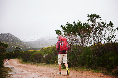 Buy stock photo Hiking, back view and man with walk outdoor for travel, backpack and nature for fresh air and fitness. Trekking, mountain trail and rough terrain for adventure, journey and exercise in environment