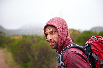 Buy stock photo Nature, travel and man with backpack in rain, hoodie and walking on landscape, fresh air and wellness. Forest, trekking or hiking of male person for exercise, health or camping for holiday and trip