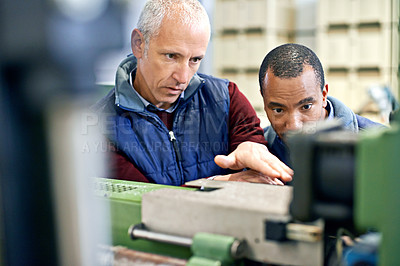 Buy stock photo Shot of two men working over factory machinery