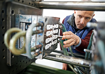 Buy stock photo Shot of a mature man working on machinery