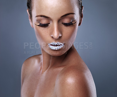 Buy stock photo Skin, face and woman with crystal on lips in studio with jewelry isolated on gray background. Diamond, sparkle and model with creative makeup for beauty, cosmetics or art for aesthetic with lipstick