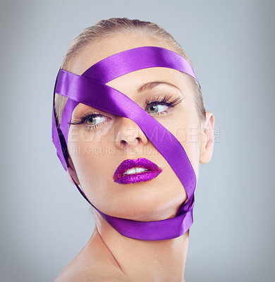 Buy stock photo Closeup studio shot of an attractive woman with purple lipstick wrapped in a purple ribbon