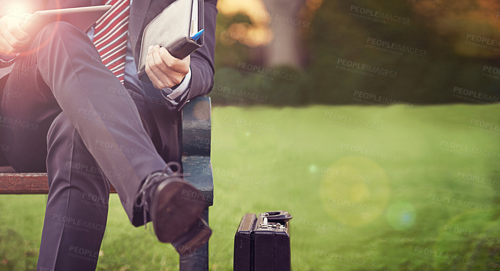Buy stock photo Businessman, leg and sitting with tablet in park for planning, schedule or waiting in park. Nature, lens flare and man with notebook on bench for idea, working and technology outdoors with bokeh