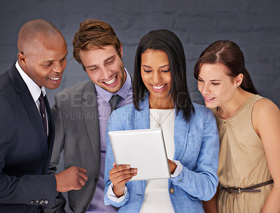 Buy stock photo Shot of a group of businesspeople working over a digital tablet