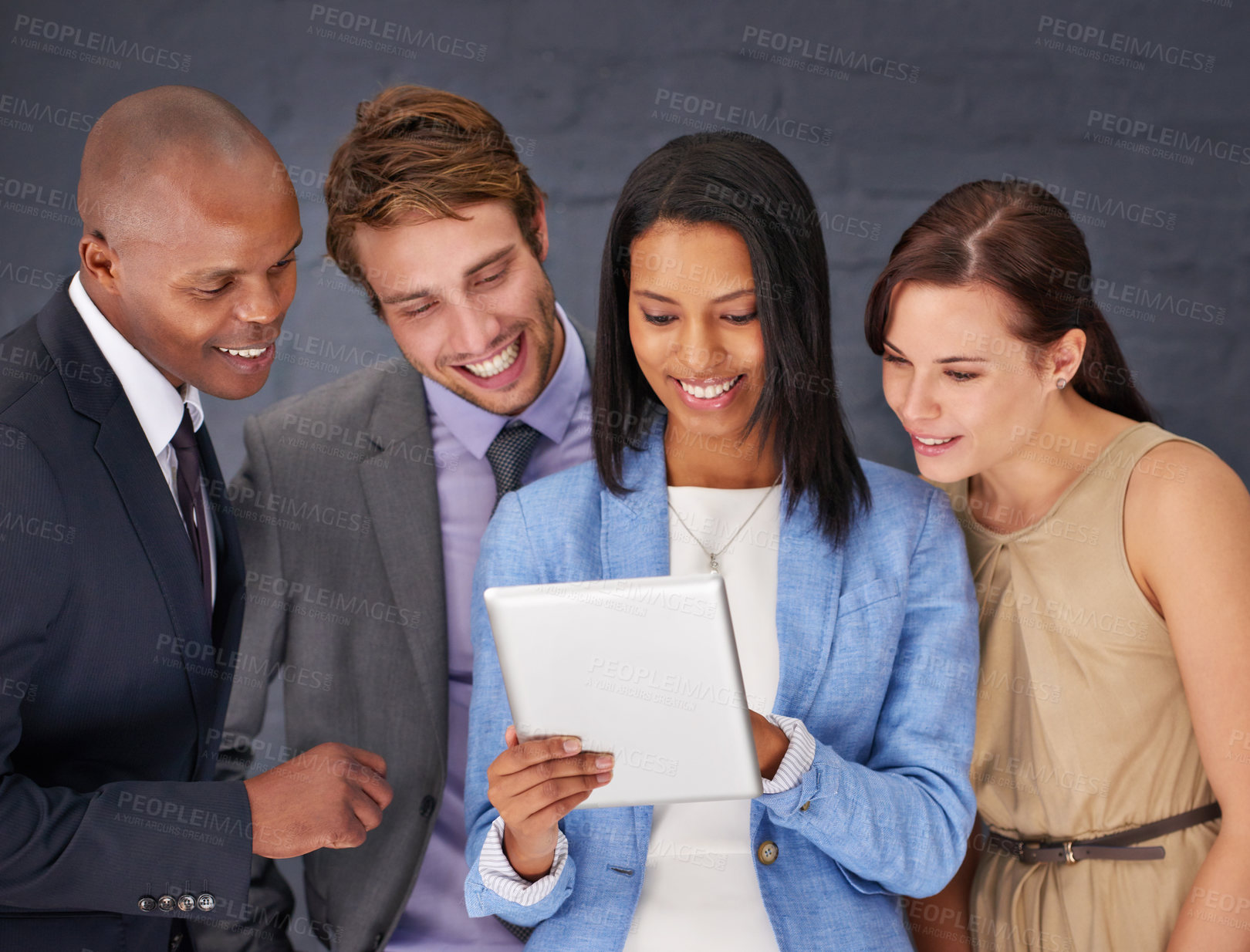 Buy stock photo Shot of a group of businesspeople working over a digital tablet