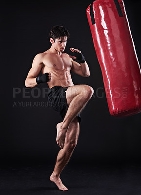 Buy stock photo Man, athlete and boxing bag with kick in studio for self defence fighter, martial arts or black background. Male person, wellness and mockup space for strength training with gym, fitness or sport
