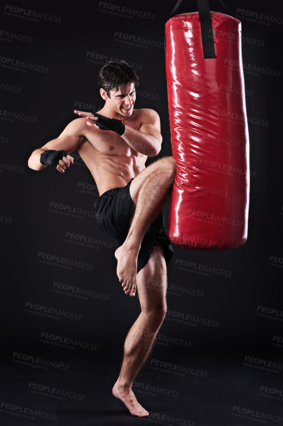 Buy stock photo Man, fighter and boxing bag with kick in studio for self defence workout, martial arts or black background. Male person, wellness and mockup space for strength training with gym, fitness or sport