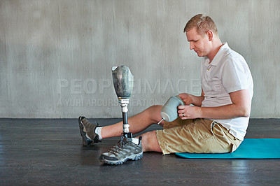 Buy stock photo Man, amputee and prosthetic leg in gym sitting to attach, residual limb for assemble. Gym workout, physiotherapy and fitness for wellness of male person with a disability, exercise and rehabilitation
