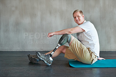 Buy stock photo Shot of a young amputee working out on a gym floor