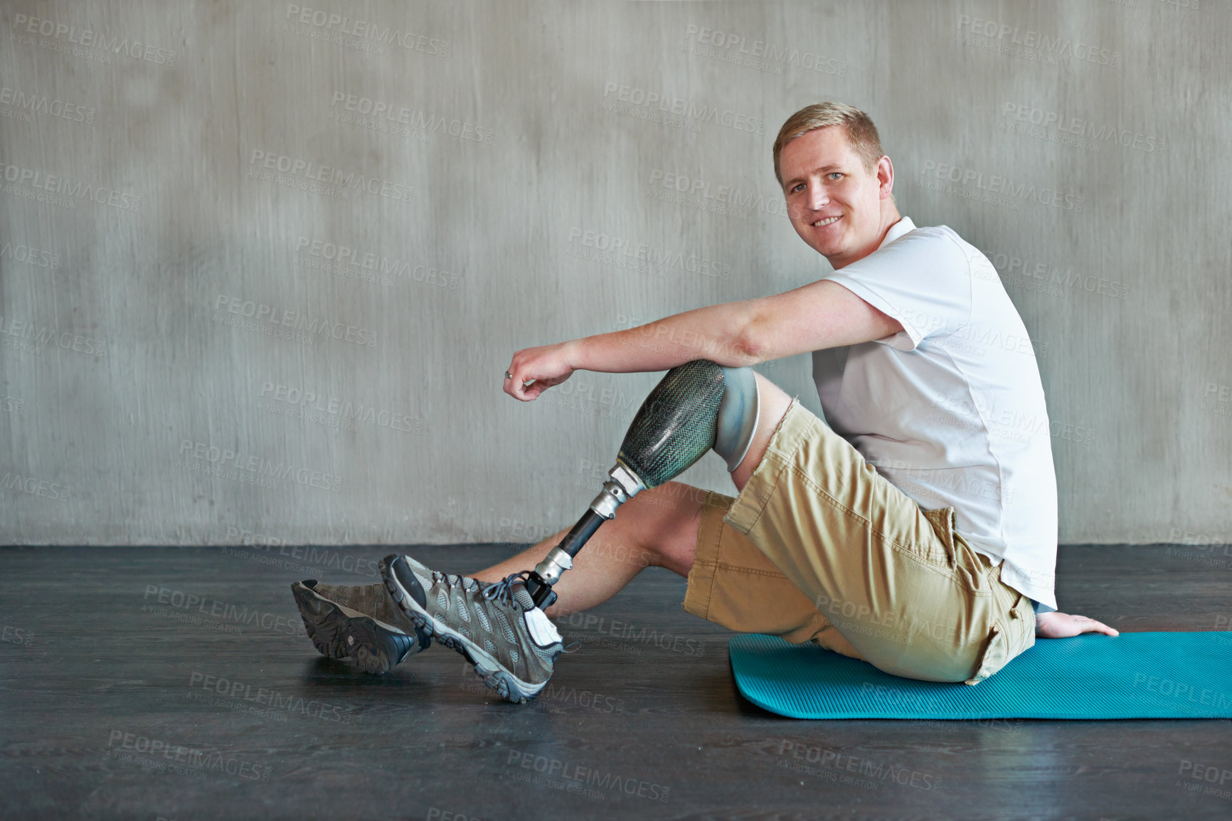 Buy stock photo Shot of a young amputee working out on a gym floor