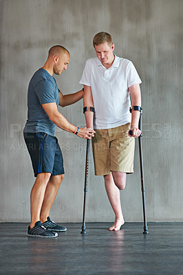 Buy stock photo Man, amputee and crutches in physical therapy with personal trainer for rehabilitation and recovery. Male person with disability, exercise and fitness growth for health, vitality and strength 