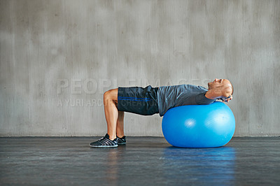 Buy stock photo Man, fitness and stretching with exercise ball for workout, training or balance at gym. Active male person lying on round object, equipment or support for warm up, health and wellness on mockup space