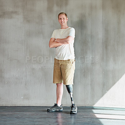 Buy stock photo Shot of a young man with an artificial leg standing confidently in a gym