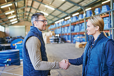 Buy stock photo Shot of two people whaking hands while working in a warehouse