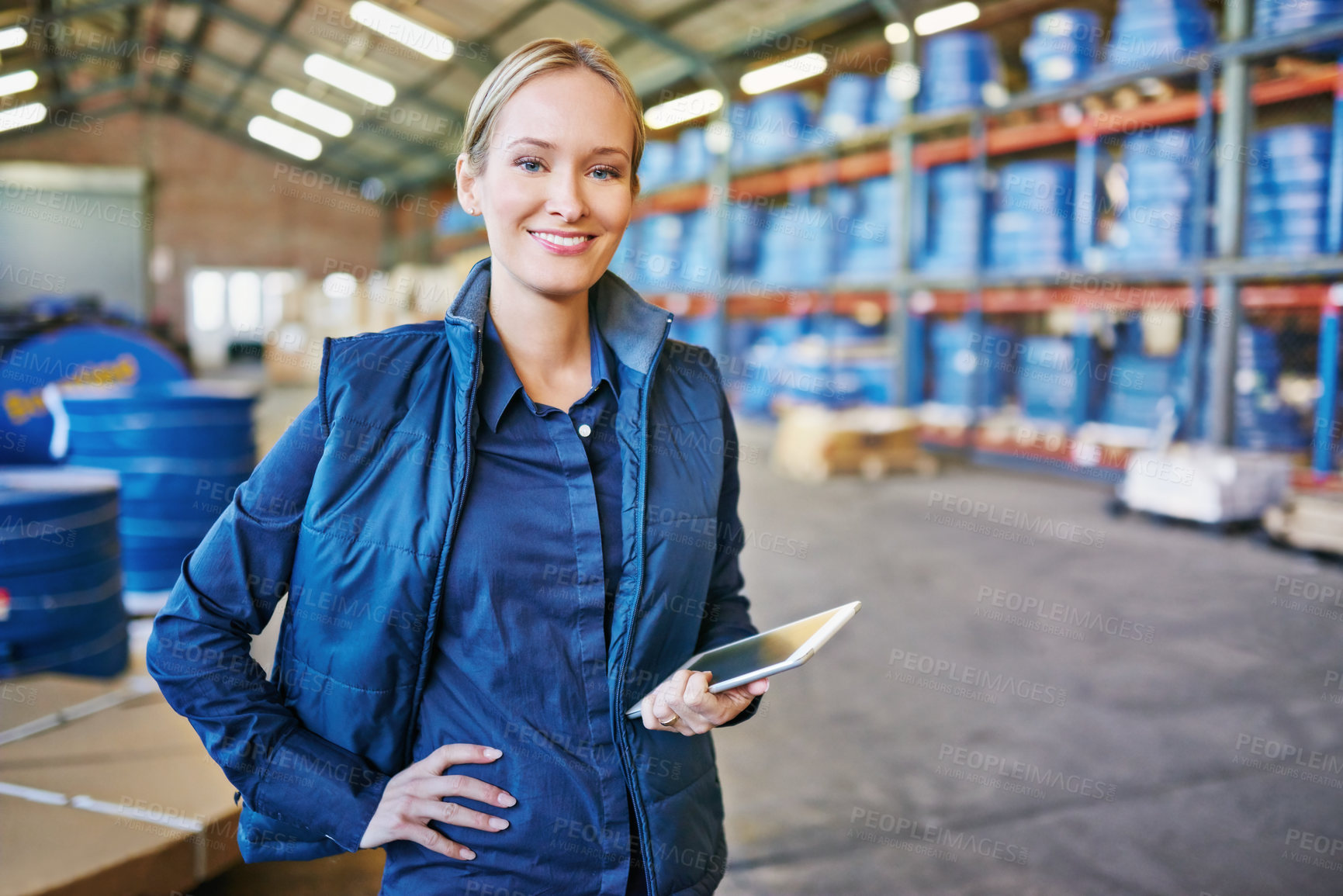 Buy stock photo Shot of a woman using a digital tablet in a large warehouse