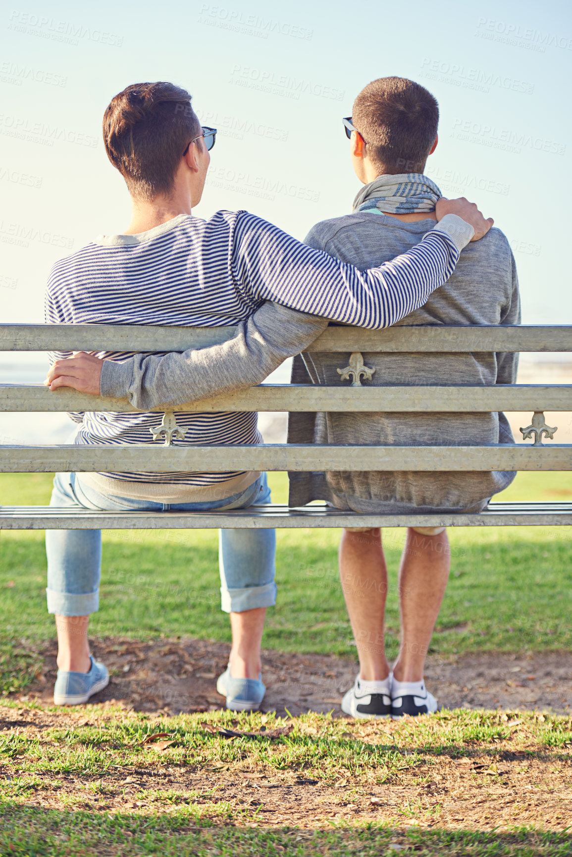 Buy stock photo Couple, gay and men for hugging with park bench, nature and honeymoon at beach. Male tourists, sunlight and summer vacation for romance with partner, relaxing and travel on grass in Cape Town