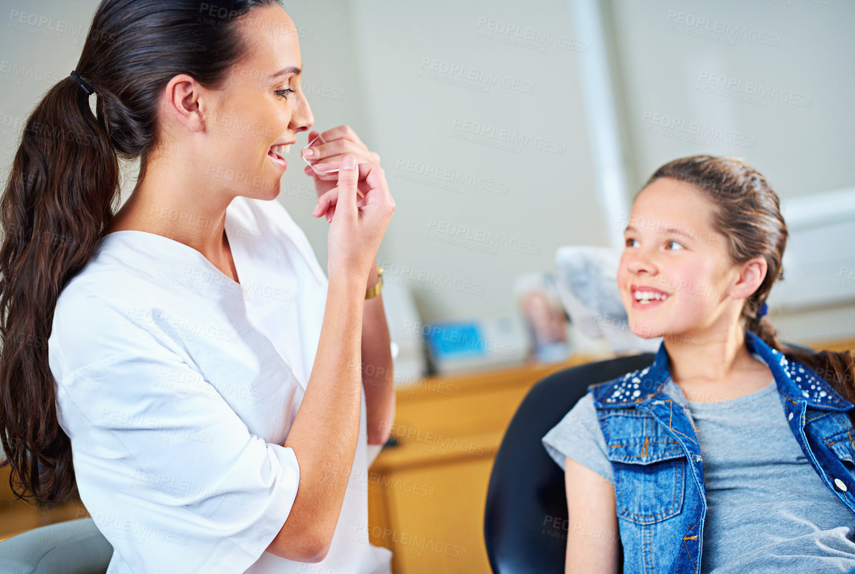 Buy stock photo Professional, dentist and child with floss, girl or smile in a modern office or wellness with care. Trust, support or oral hygiene with string or patient with dental healthcare or cheerful with child