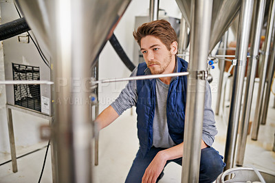 Buy stock photo Brewery, production and man with steel in factory or distillery for winery, alcohol and drink manufacturing. Worker or winemaker checking container, metal or pipe of fermentation vessel for beer 