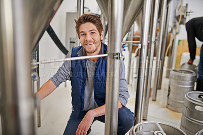 Buy stock photo Brewery, production and man in portrait and factory or distillery for winery, alcohol and drink manufacturing. Worker or winemaker working by tank, metal or steel pipe of fermentation vessel for beer