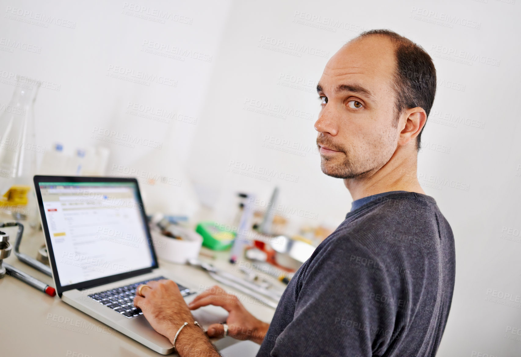 Buy stock photo Man, laptop and equipment in workshop, brewery and portrait with scroll, research and development. Person, computer and typing at factory on web for alcohol, craft beer and tools on desk in warehouse