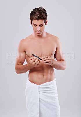 Buy stock photo Man, nails and grooming with filler for beauty, hygiene or skincare on a gray studio background. Muscular male person or young model cleaning or filing finger tips with cosmetic tool on mockup space
