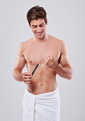 Buy stock photo Studio shot of a handsome young shirtless man filing his nails