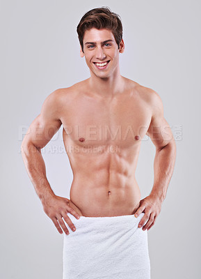 Buy stock photo Studio shot of a bare-chested young man with a towel wrapped around his waist