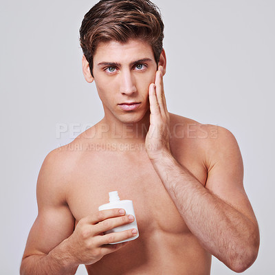 Buy stock photo Man, portrait and aftershave with skincare, lotion or cream for cosmetics on a gray studio background. Face of male person or model with beauty creme, container or bottle for hygiene on mockup space