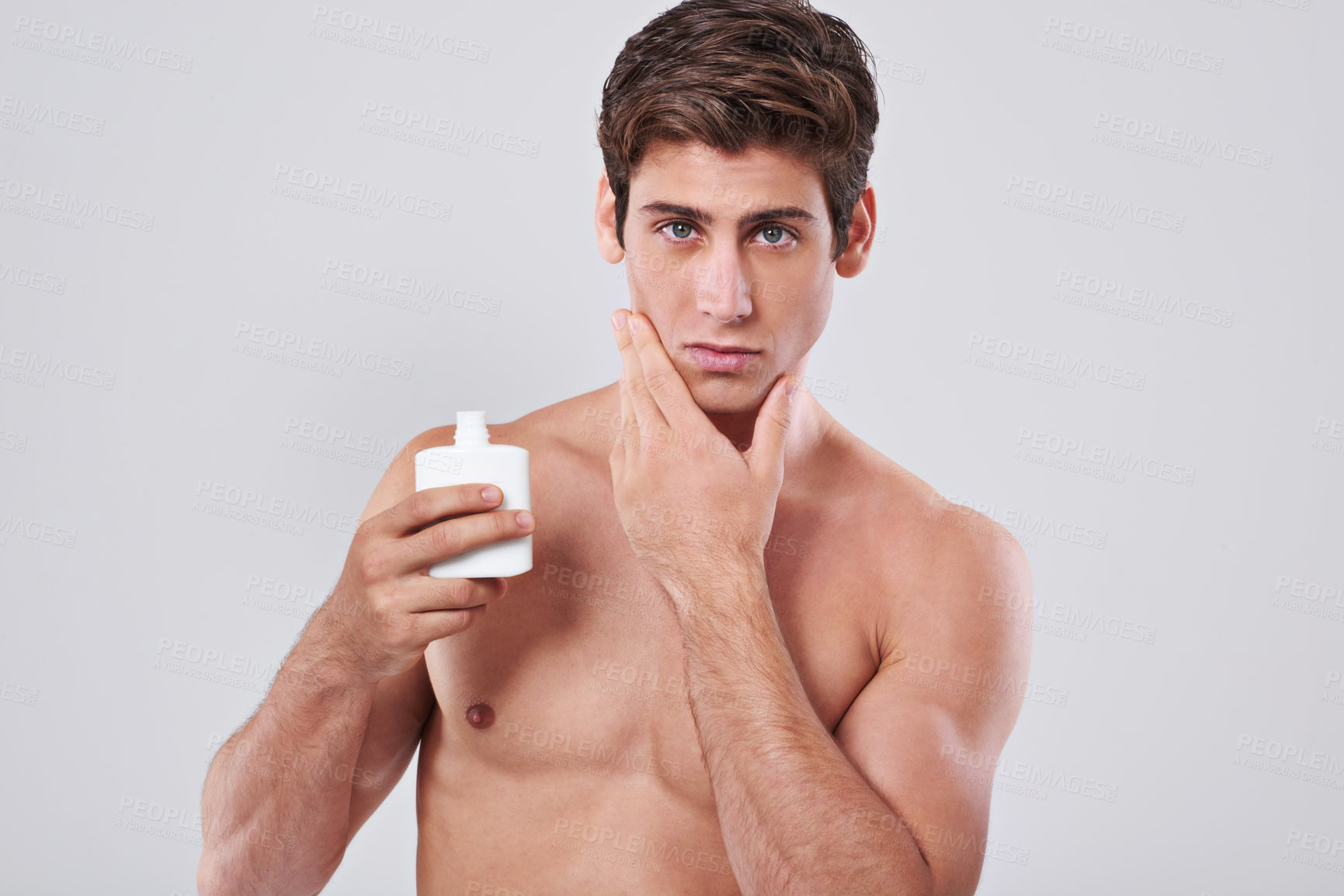 Buy stock photo Handsome man, portrait and grooming with aftershave, skincare cosmetics or lotion on a gray studio background. Young male person or model with beauty cream or container for hygiene on mockup space