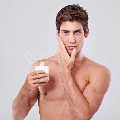 Buy stock photo Handsome man, portrait and facial with skincare for grooming, cosmetics or aftershave on a gray studio background. Face of young male person with beauty cream or container for hygiene on mockup