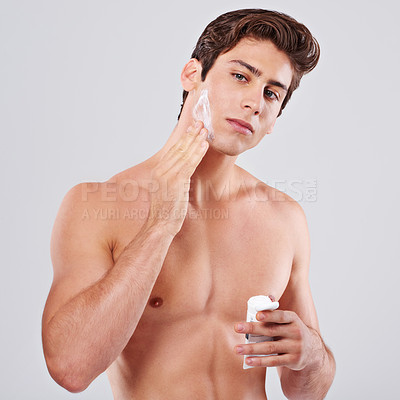 Buy stock photo Man, portrait and skincare with facial cream for grooming or hygiene on a gray studio background. Handsome male person or young masculine model with face lotion, creme or moisturizer on mockup space